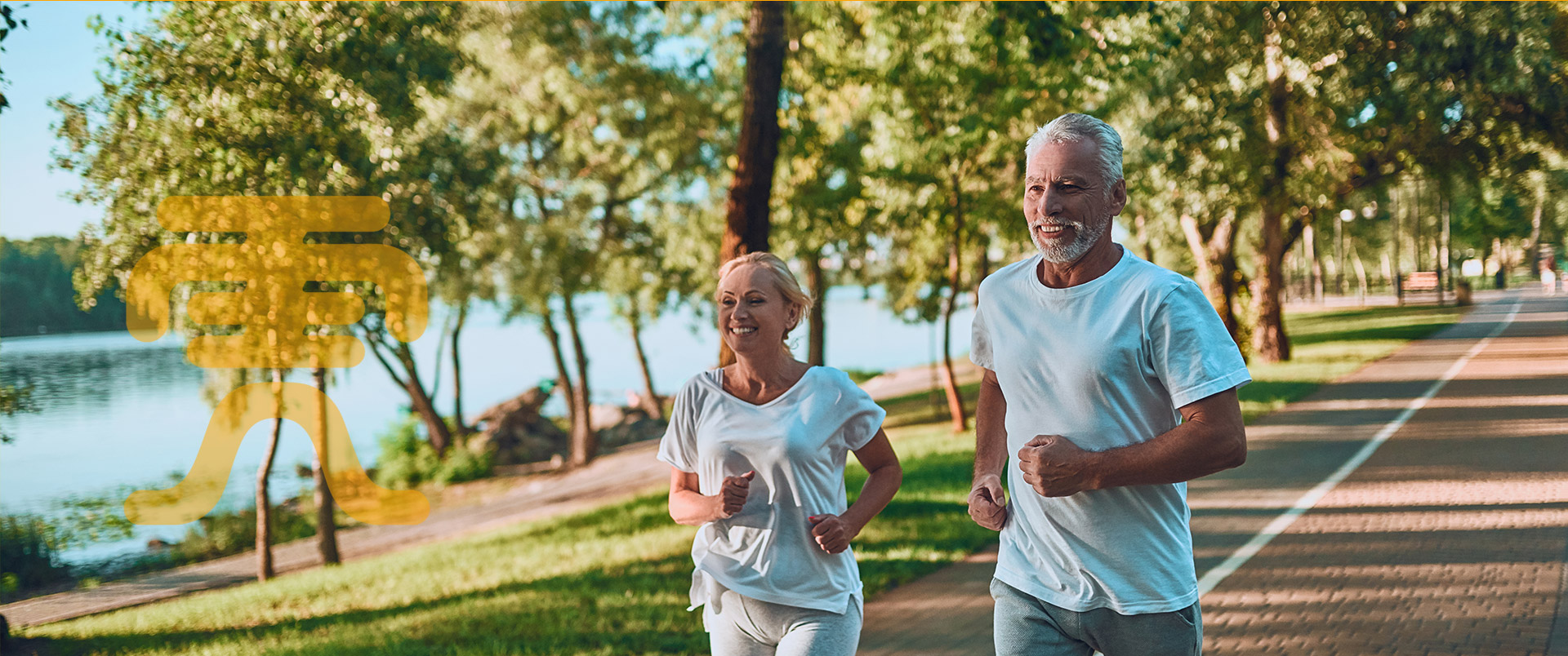 Senior man and woman jogging in a park by the sea